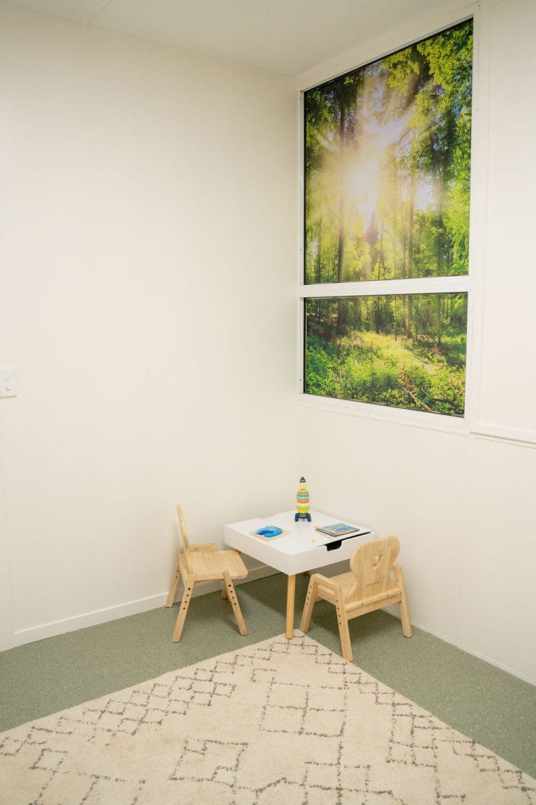 A room with a table and chairs and a window.