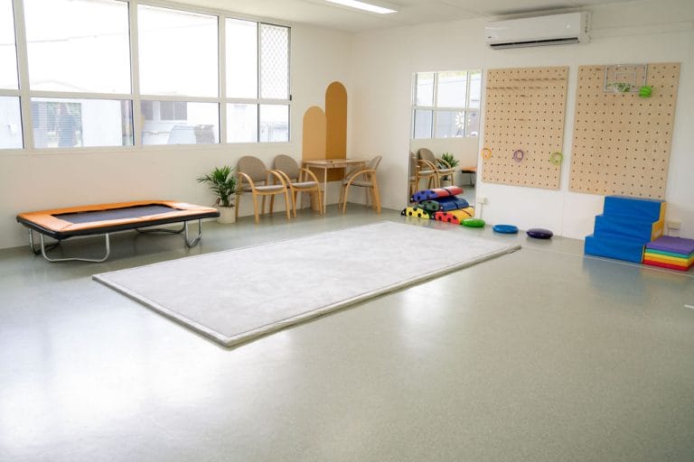 A child's playroom with toys and a trampoline.